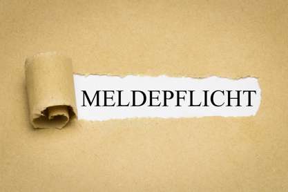 Foto: Aufgerissenes Papier mit Aufschrift Meldepflicht