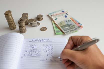 Foto: Person schreibt in Haushaltsbuch